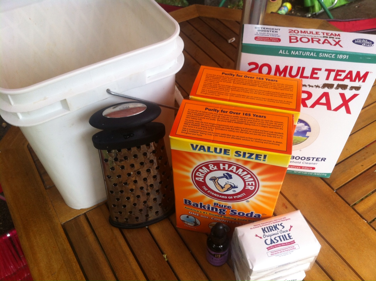 DIY laundry detergent with an empty litter bucket, Borax, baking soda, and castile soap