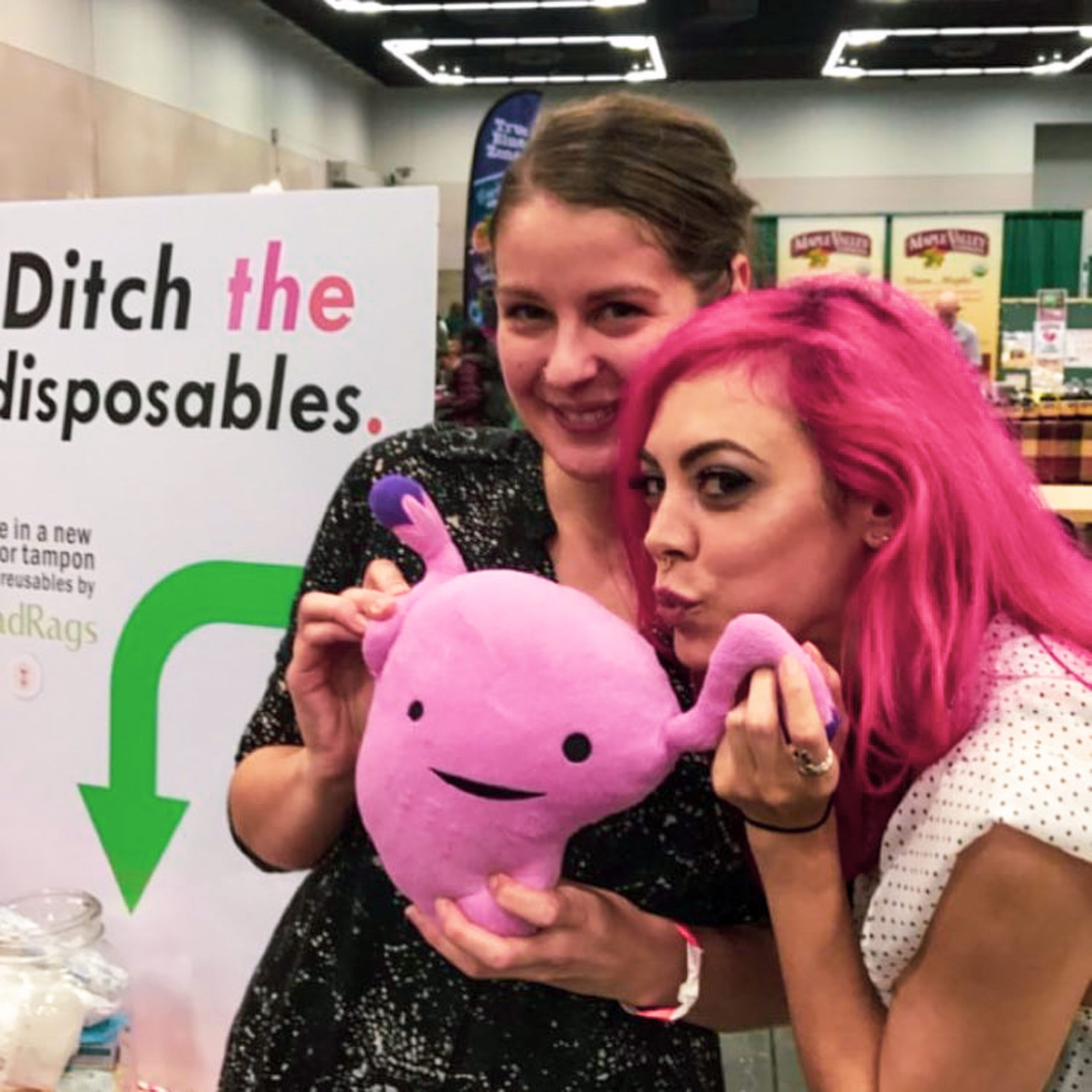 GladRags CEO Tracy with @veganbeautyreview at Portland VegFest, holding a plus uterus.