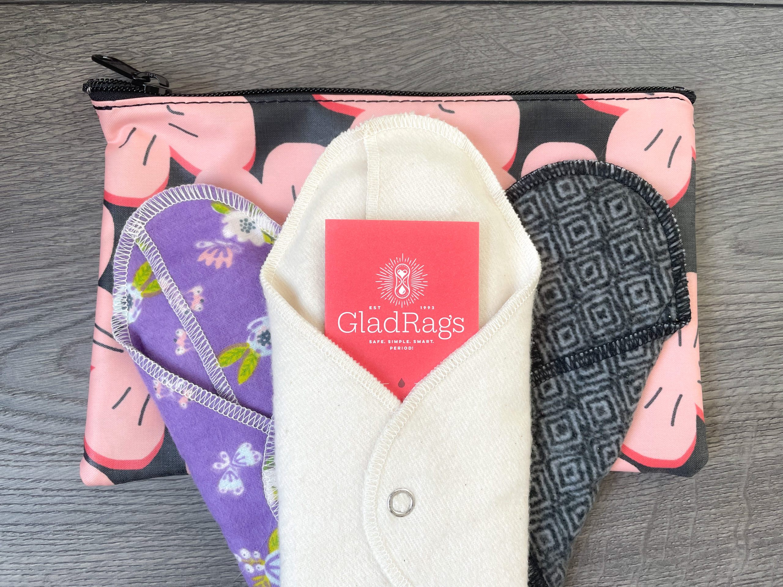 A trio of cloth pads lay on top of a zippered carry bag.